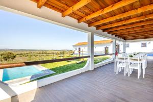 a house with a view of a patio with a table and chairs at Quinta do Grande Lago in Reguengos de Monsaraz