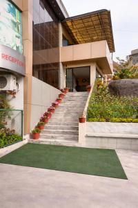 a staircase leading to a building with a green lawn at Hotel Ashoka Mountabu in Mount Ābu