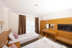 a hotel room with two beds and a television at Elit Life Otel - All Inclusive in Kemer +59 photos
