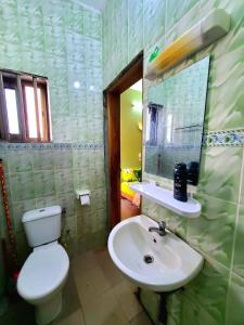 a bathroom with a white toilet and a sink at Green Appart 1 chambre et salon in Cotonou +12 photos