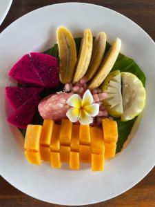 a plate of food with fruit and vegetables on it at Santhi Loka in Kubupenlokan