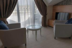 a living room with a tv and a table and chairs at Elit Life Otel - All Inclusive in Kemer