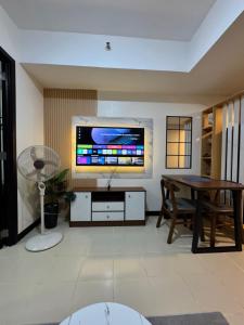 a living room with a table and a large television at JI Homestaycation in Manila