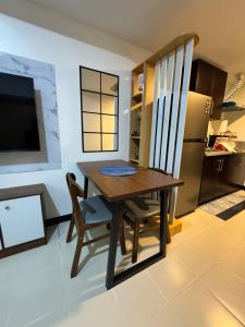 a kitchen with a table and a chair and a refrigerator at JI Homestaycation in Manila