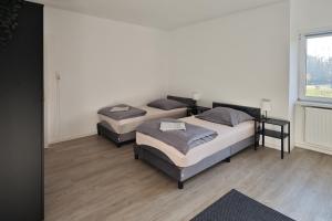 two beds in a room with a window at Gemeinschaftswohnung mit privaten Zimmern in Diepholz