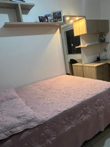 a bedroom with a bed with a pink bedspread at Energia Boa Estadia in Palhoça
