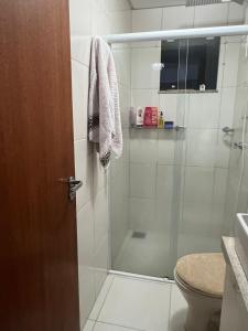 a bathroom with a shower with a glass door at Energia Boa Estadia in Palhoça