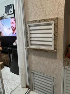 a door with a window in a room with a tv at Energia Boa Estadia in Palhoça