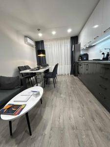 ein Wohnzimmer mit Sofa und Tisch und eine Küche in der Unterkunft Mateo in Ruse