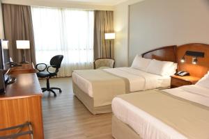 a hotel room with two beds and a desk at InterTower Hotel in Santa Fe