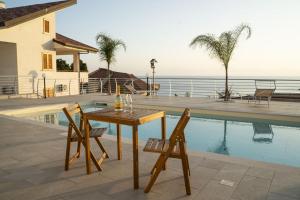 a table and chairs next to a swimming pool at Villa Acquamarina, Family apartments with pool - 300 meters from the beach in Santa Maria