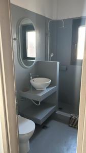 a bathroom with a sink and a toilet and a mirror at Ammos Boutique Villa in Elafonisos +14 photos