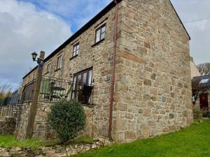 an old stone house with a brick wall at Saddle Cottage in Penzance