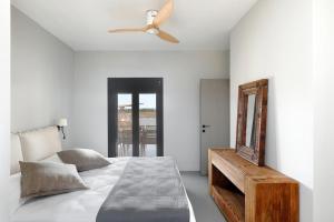 a bedroom with a bed with a ceiling fan and a mirror at Ammos Boutique Villa in Elafonisos
