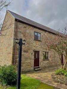 a stone house with a light pole in front of it at Saddle Cottage in Penzance +32 photos