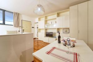 a kitchen with white cabinets and a table with wine glasses at Sergio's house in Como +20 photos