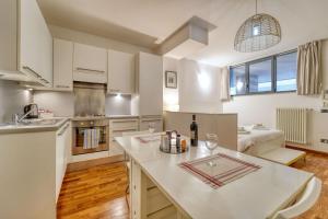 a kitchen with white cabinets and a white counter top at Sergio's house in Como