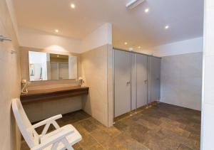 a bathroom with a white chair and a mirror at Camping Bergkristall in Moso