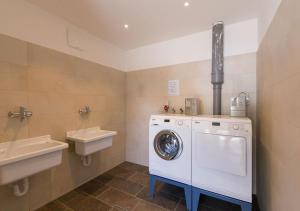 a bathroom with a washing machine and a sink at Camping Bergkristall in Moso
