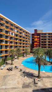 a resort with a pool and palm trees and a hotel at PB329 Phuket's best oceanfront studio in Ban Mai Salae