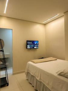 ein Schlafzimmer mit einem Bett und einem Fernseher an der Wand in der Unterkunft TERESINA HOTEL in Teresina