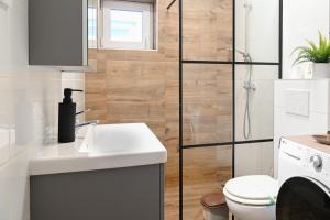 a bathroom with a toilet and a sink and a shower at Majoros Garden Apartman in Siófok