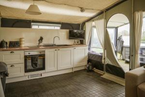 a kitchen in a tent with a sink and a stove at King Fisher in Nantmel