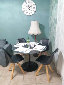 a table with four chairs and a clock on the wall at Schöne Wohnung Prima am Bahnhof Schwerte in Schwerte