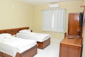 a hotel room with two beds and a television at Requinte Hotel in Altamira +2 photos