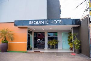 a hotel with a blue sign on the front of a building at Requinte Hotel in Altamira