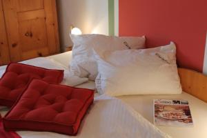 a bed with two pillows and a red chair on it at Pihringer's Moststub'n in Amstetten