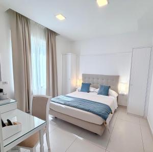 a bedroom with a bed with blue pillows and a table at Ravello 23 Accommodation in Ravello