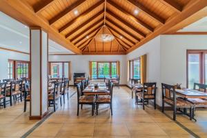 a dining room with wooden ceilings and tables and chairs at Silver Crest Resort in Thekkady
