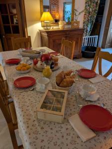 a table with red plates and food on it at Les Chardonnerets in Villemandeur