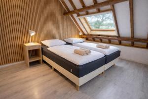 a bedroom with two beds and a window at Ballumerhoeve Skip lodge in Ballum