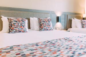 a large white bed with pillows in a bedroom at Armagh City Hotel in Armagh