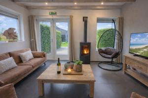 a living room with a couch and a table at Ballumerhoeve Skip lodge in Ballum