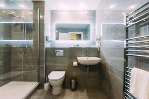 a bathroom with a toilet and a sink and a shower at Armagh City Hotel in Armagh