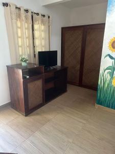 a living room with a tv on a dresser at Hotel de Charme Castelinho in Canoa Quebrada