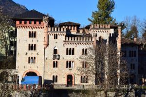 an old brick castle on the side of a river at Ponte House in Piaia
