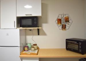 a kitchen with a counter with a microwave and a refrigerator at Ponte House in Piaia