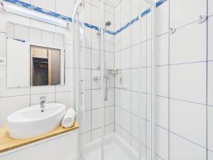 a white bathroom with a sink and a shower at Boutique73 Sunrise in Ossiach +22 photos