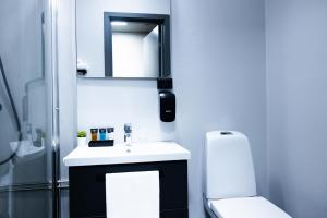a bathroom with a sink and a mirror and a toilet at Vardø Hotel by Destination Vardø in Vardø