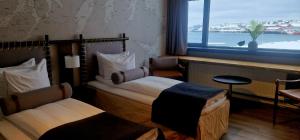 a hotel room with two beds and a window at Vardø Hotel by Destination Vardø in Vardø
