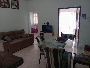 a living room with a glass table and a couch at Aluguel de quarto com suite in Aracaju
