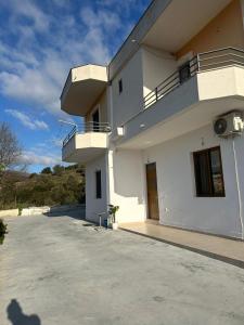 a large white building with a balcony on it at Andi's GuestHouse in Sarandë