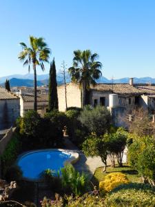 a garden with a swimming pool and palm trees at The Windmill, Garden House in Llubí