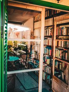 a library with a table and some books at The Windmill, Garden House in Llubí