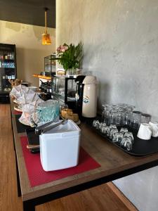 a table with glasses and other items on it at Orla Pousada & Café in Parnamirim