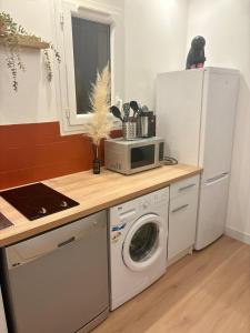 a kitchen with a white refrigerator and a washing machine at CAVALOC T2 terrasse vue colline in Cavalaire-sur-Mer